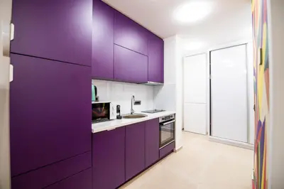 a kitchen with purple cabinets and a sink at City Center - Colors Apartment with Garage in Belgrade