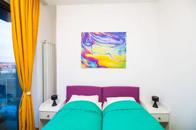 a bedroom with a bed and a painting on the wall at City Center - Colors Apartment with Garage in Belgrade