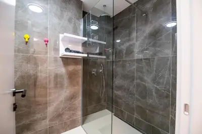 a bathroom with a shower with a glass door at City Center - Colors Apartment with Garage in Belgrade