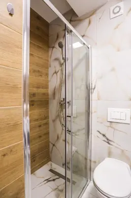 a bathroom with a glass shower with a toilet at DreamLand Apartment in Surčin