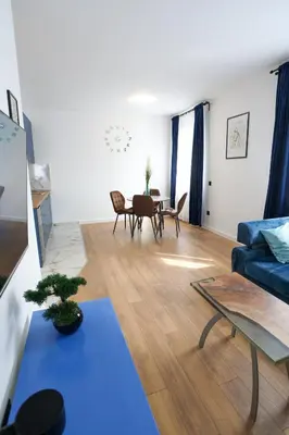 a living room with a blue couch and a table at DreamLand Apartment in Surčin
