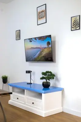 a tv on a wall with a blue table at DreamLand Apartment in Surčin