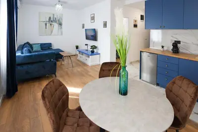 a kitchen and living room with a table and chairs at DreamLand Apartment in Surčin