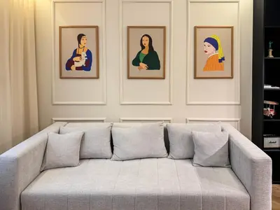 a couch in a living room with four pictures on the wall at Momentum in Belgrade