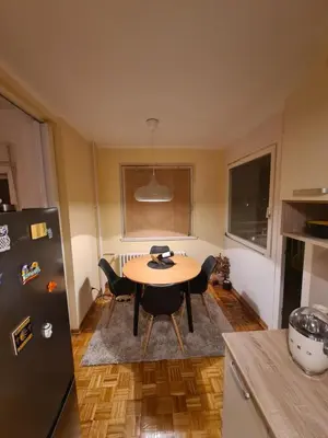 a kitchen with a table and chairs and a refrigerator at 70 square meters in Block 61 in Bežanija