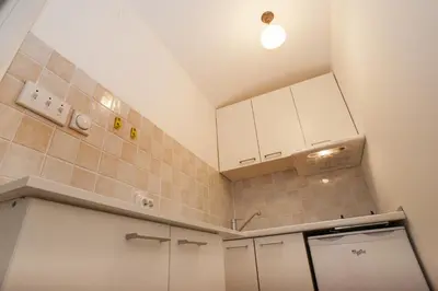 a small kitchen with white cabinets and a sink at Atelier 1 Apartment in Belgrade