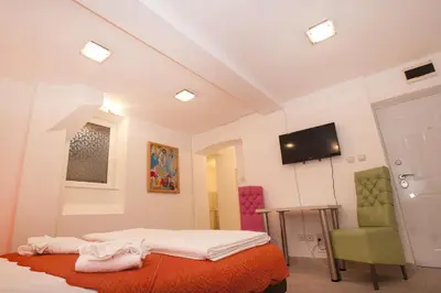 a room with a bed and a tv and a chair at Atelier 1 Apartment in Belgrade