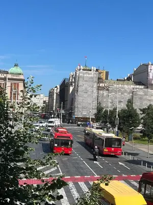 two buses parked in a parking lot in a city at Atelier 1 Apartment in Belgrade