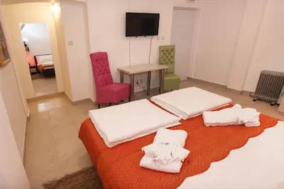 a room with two beds and a table and a television at Atelier 1 Apartment in Belgrade