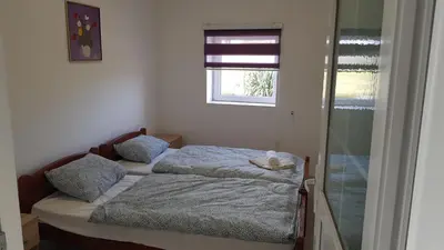 a small bedroom with two beds and a window at BigNest in Smederevo