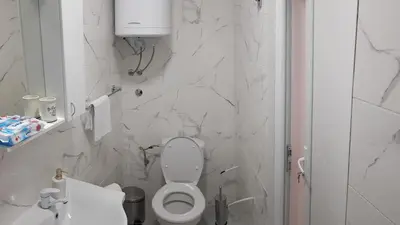 a white bathroom with a toilet and a sink at BigNest in Smederevo