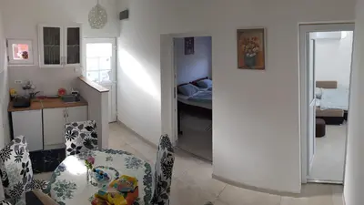 a living room with a table and chairs and a kitchen at BigNest in Smederevo