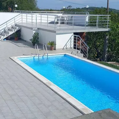 a large blue swimming pool with a staircase next to a building at BigNest in Smederevo