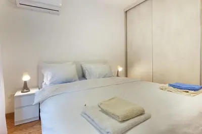 a bedroom with a white bed with two towels on it at The 7 Apartment - Modern Flat with Terrace near Parliament, Belgrade Center in Belgrade