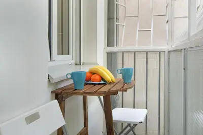 a table with a bowl of fruit and two blue cups at The 7 Apartment - Modern Flat with Terrace near Parliament, Belgrade Center in Belgrade