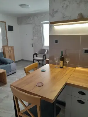 a kitchen with a wooden table with two wine glasses at Nemanjina Centar in Pančevo