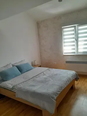 a bedroom with a bed with blue pillows and a window at Nemanjina Centar in Pančevo