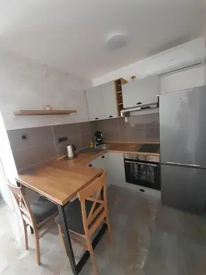 a kitchen with a wooden table and a refrigerator at Nemanjina Centar in Pančevo