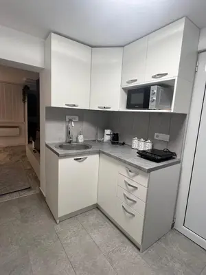 a kitchen with white cabinets and a sink at Agate Apartment in Belgrade