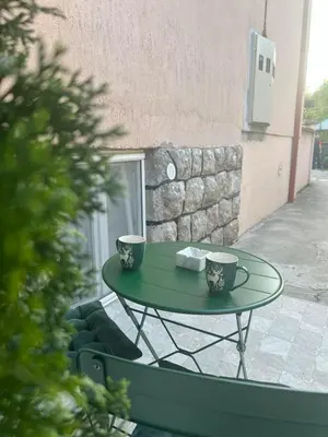 a green table with two cups on a patio at Agate Apartment in Belgrade