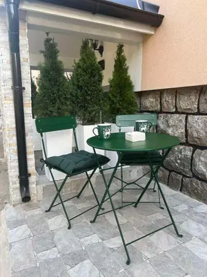 a green table and two chairs on a patio at Agate Apartment in Belgrade
