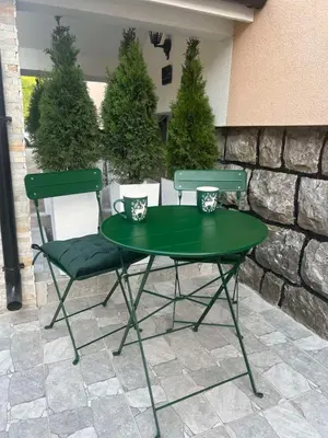 a green table and two chairs on a patio at Agate Apartment in Belgrade