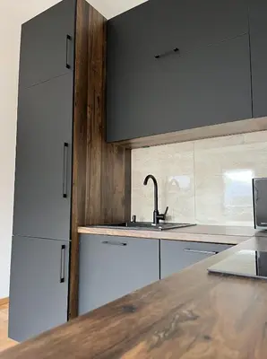 a kitchen with white cabinets and a sink and a counter at Residence 25V in Batajnica