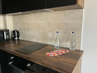 a kitchen counter with two bottles of water and snacks at Residence 25V in Batajnica