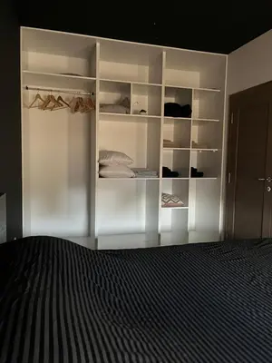 a bedroom with white shelves and a bed at Residence 25V in Batajnica