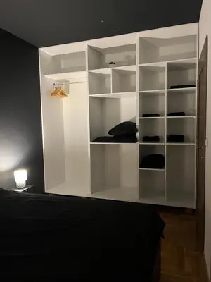 a white closet with shelves in a bedroom at Residence 25V in Batajnica