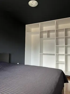 a bedroom with white shelves and a bed at Residence 25V in Batajnica