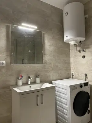 a bathroom with a sink and a washing machine at Residence 25V in Batajnica