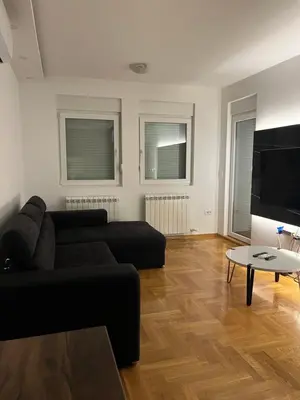 a living room with a black couch and a table at Residence 25V in Batajnica
