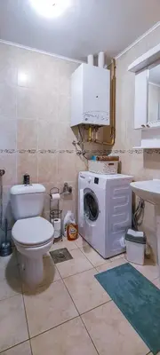a bathroom with a toilet a sink and a washing machine at Dina cozy apartment in Zemun