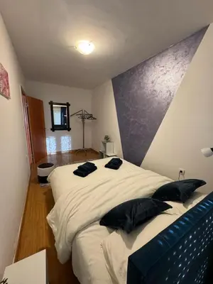 a bedroom with a large white bed with black pillows at Studio29 in Ruma