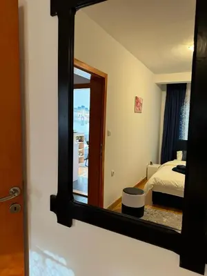a mirror in a room with a bed and a bedroom at Studio29 in Ruma