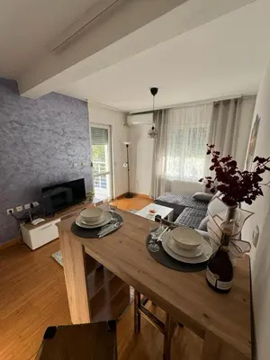 a living room with a table with plates and flowers on it at Studio29 in Ruma
