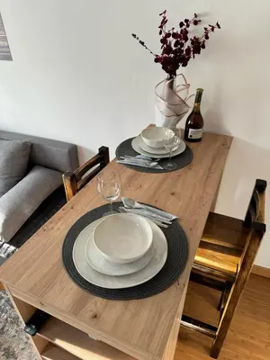 a wooden table with plates and wine glasses on it at Studio29 in Ruma