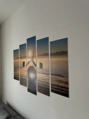 a wall with four paintings of a beach at Studio29 in Ruma