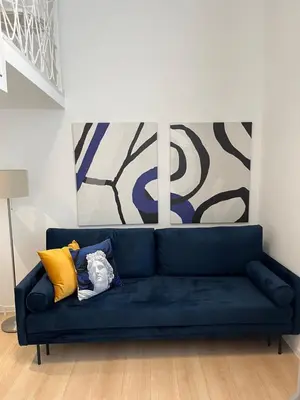 a blue couch in a living room with paintings at Mina Luxury Suite 1 in Belgrade
