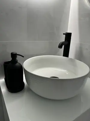 a white sink with a soap dispenser on a bathroom counter at Mina Luxury Suite 1 in Belgrade