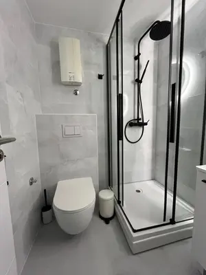 a white bathroom with a shower and a toilet at Mina Luxury Suite 1 in Belgrade