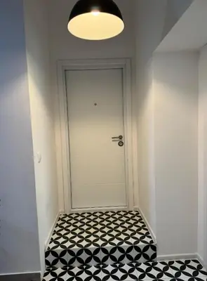 a hallway with a white door and a black and white tiled floor at Mina Luxury Suite 1 in Belgrade