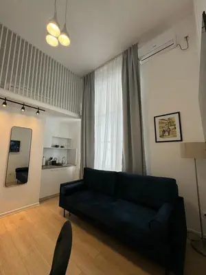 a living room with a black couch and a mirror at Mina Luxury Suite 2 in Belgrade