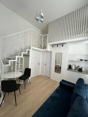a living room with a blue couch and a staircase at Mina Luxury Suite 2 in Belgrade
