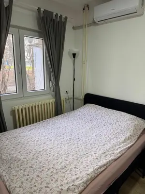 a bedroom with a bed and two windows at Sixty three in Novi Beograd
