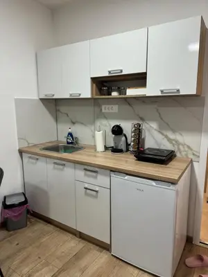 a small kitchen with white cabinets and a sink at Sixty three in Novi Beograd