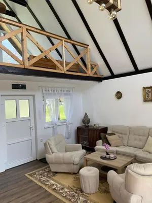 a living room with white furniture and a wooden ceiling at Vikendica Živković in Lazarevac