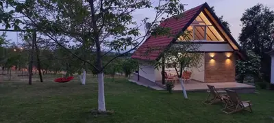 a small house with a red roof in a yard at Vikendica Živković in Lazarevac
