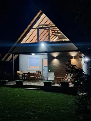 a house with a table and chairs in the night at Vikendica Živković in Lazarevac
